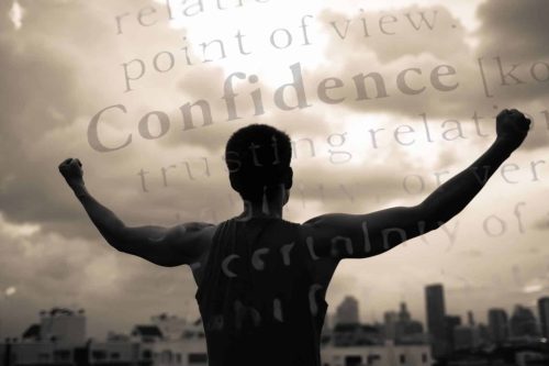 Muskulärer Mann mit kraftvoller Pose. Im Hintergrund ist das Wort "Confidence" überlagert